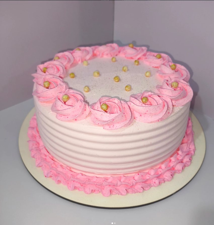 Bolo rosa com rosetas e pérolas douradas